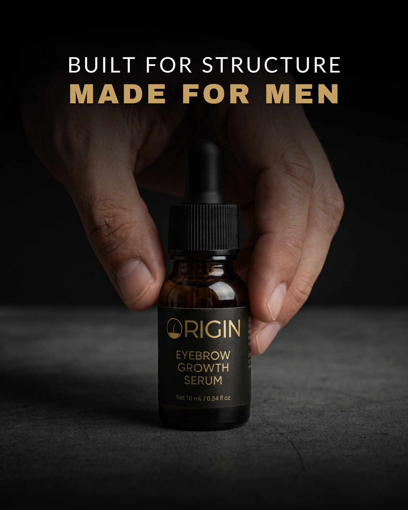 Bottle of Origin Eyebrow Growth Serum held by a hand with text 'Built for structure, made for men' on a dark background.